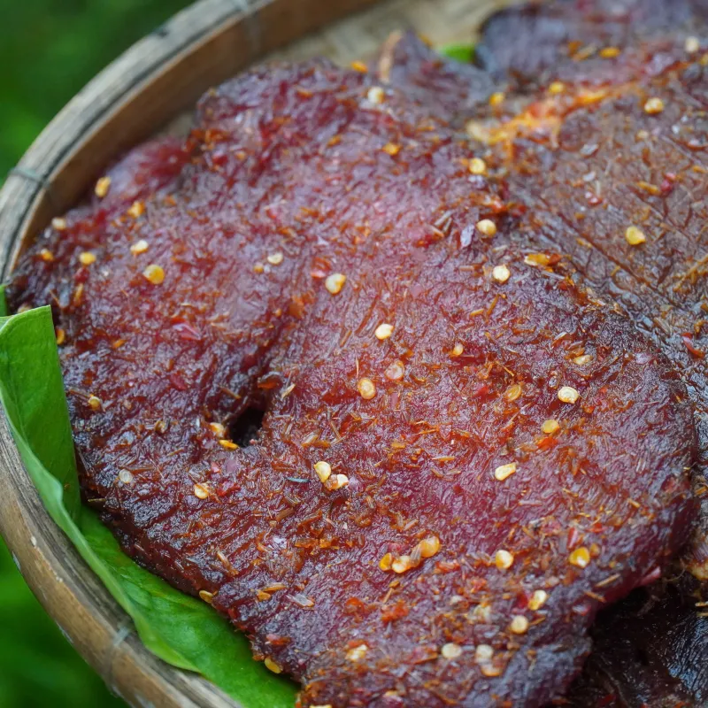 Cận cảnh miếng khô bò một nắng còn ẩm, thấy rõ ớt và gia vị ướp